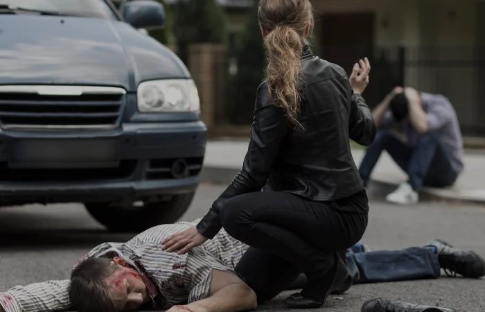 Bloody victim of car accident lying on the street