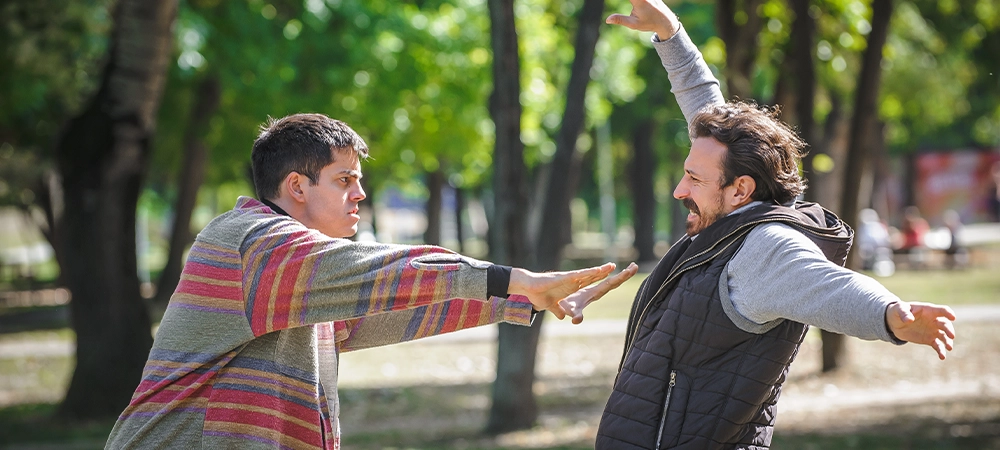 Man pushes another during quarrel. Two very angry, nervous and upset men in an aggressive and fierce conflict on the verge of a physical confrontation and a fight