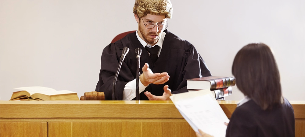 Serious young judge sitting in the courtroom with a stern facial expression