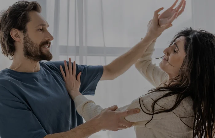 Angry man beating worried girlfriend during conflict at home