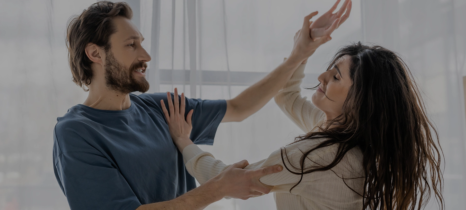 Angry man beating worried girlfriend during conflict at home