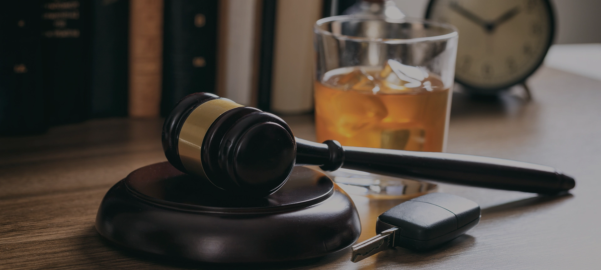 DUI concept. Law gavel, alcohol and car keys on a wooden desk, dark background