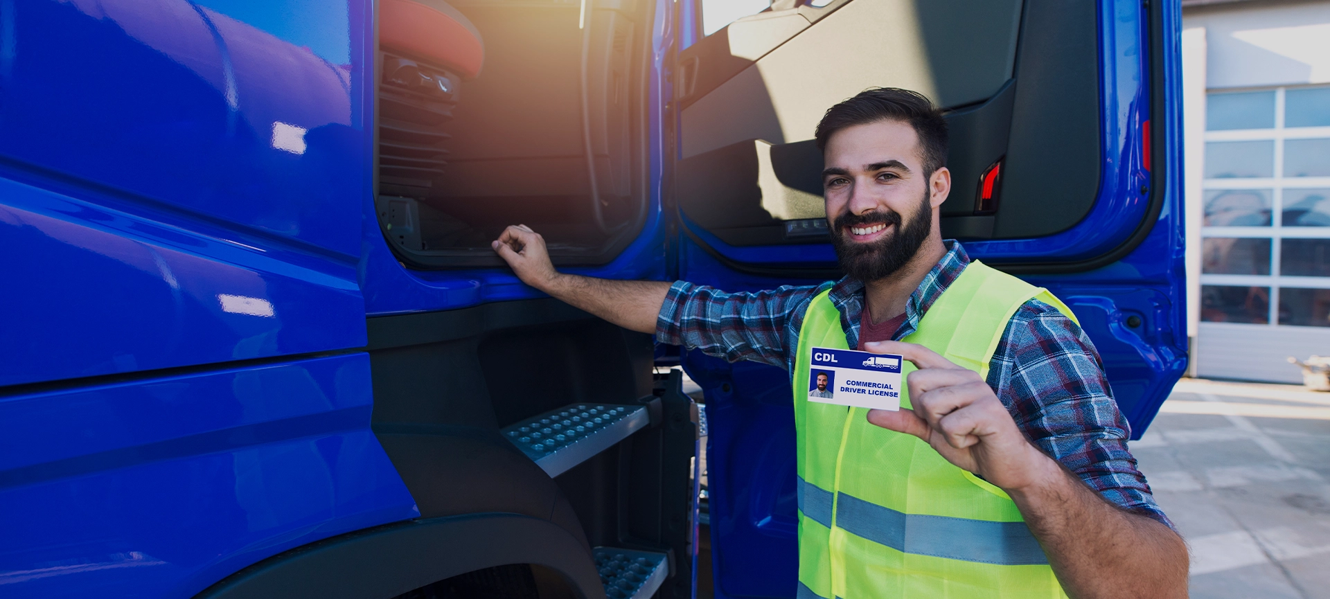 Truck driver candidate showing CDL driving license for transportation vehicles. Successfully passed training driving exam.