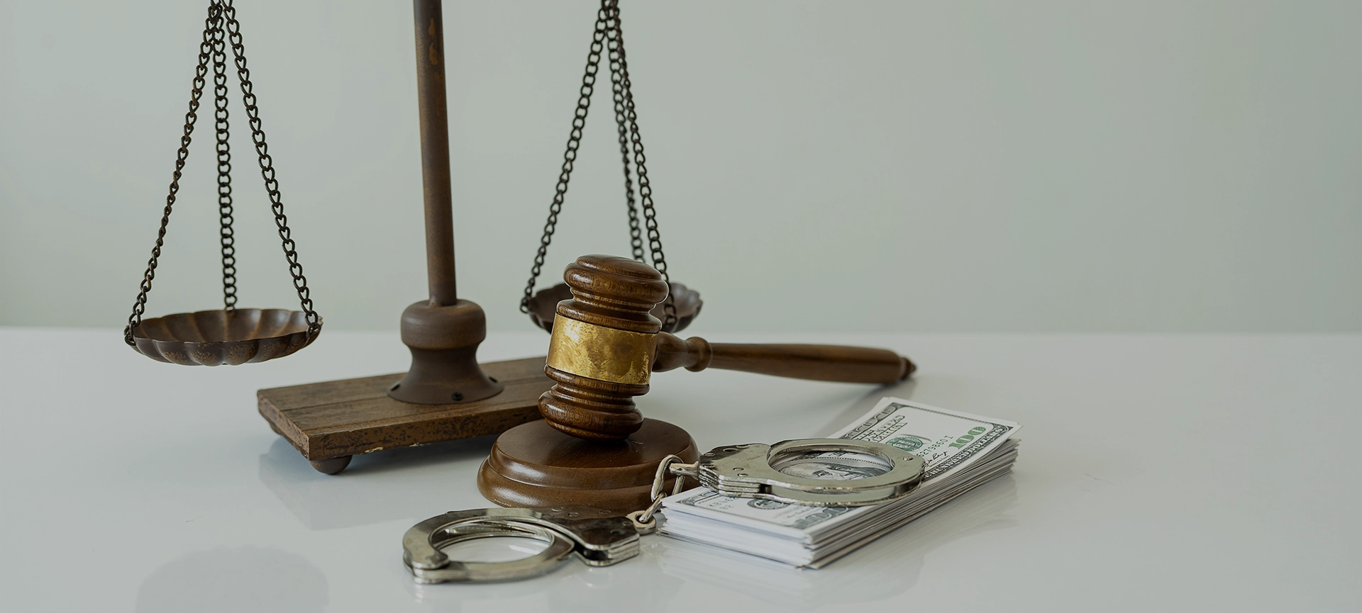 Handcuffs and dollars, scales of justice and judge's hammer on table, legal concept