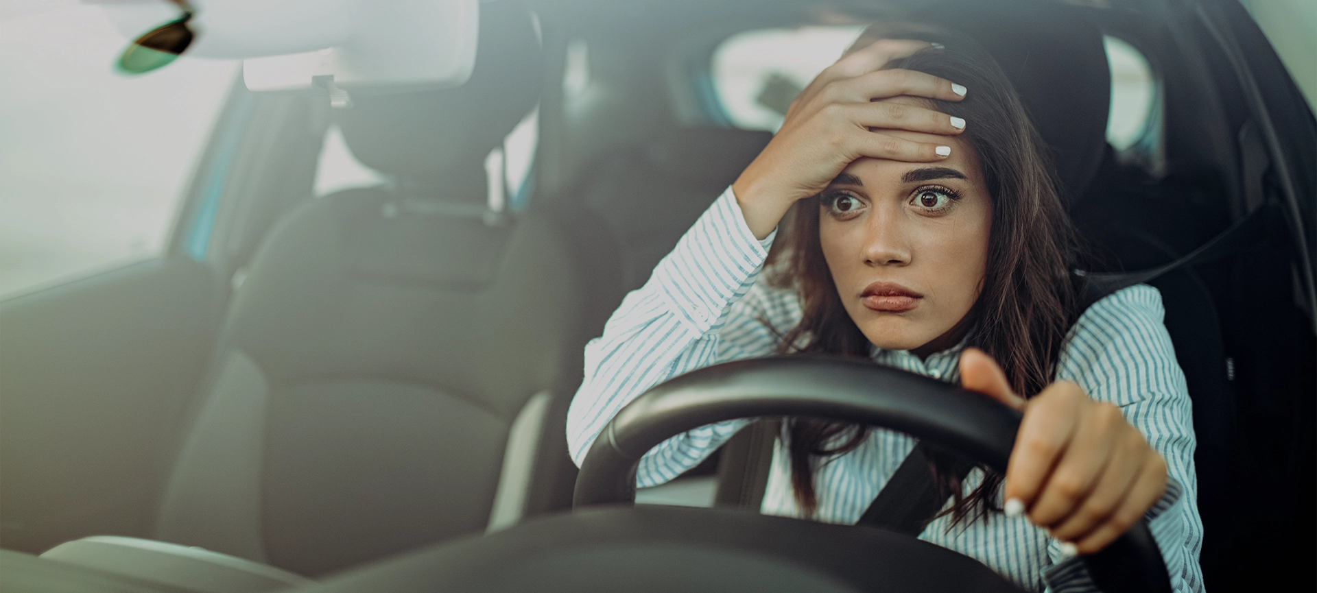 Angry woman driving a car. The girl with an expression of displeasure is actively gesticulating behind the wheel of the car. Angry business woman in a car. Stress girl in a car