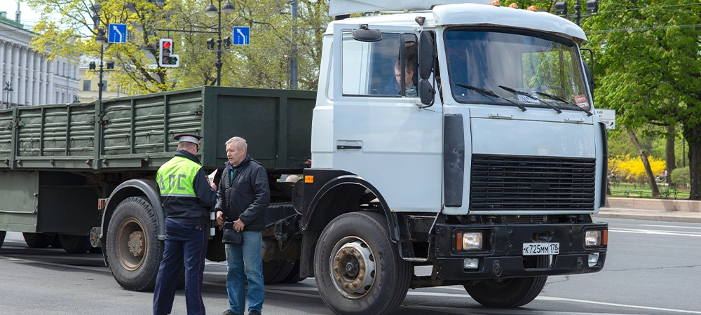 Traffic police inspector checks documents of a truck driver