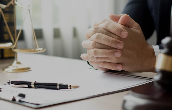 The lawyers sitting in their office is meticulously examining the judicial documents to gather crucial information and build a strong legal strategy for their client's case.
