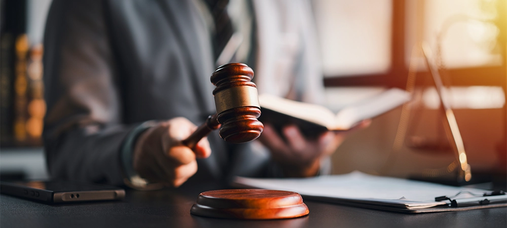 An attorney is reading a book while holding a gavel. Focus on auction legal lawyer judge courthouse trial business concept law court justice system.