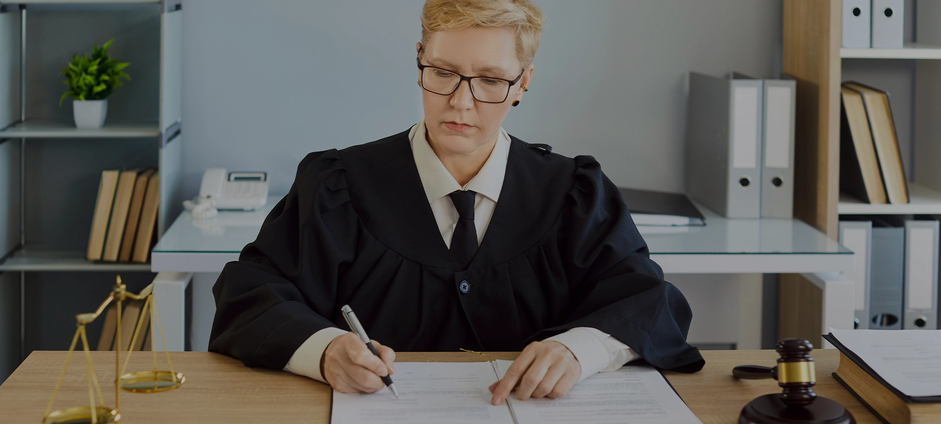 Judge serious woman in professional outfit black robe writing reviewing documents in court room at desk, examination, discussion of legal and judicial settings, lawyer consultation, case preparation